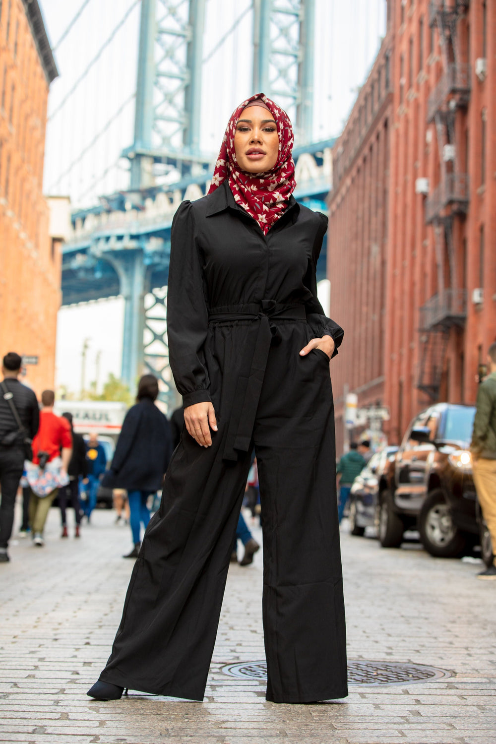 Woman in a black jumpsuit and floral hijab showcasing the Black Lattice Jumpsuit