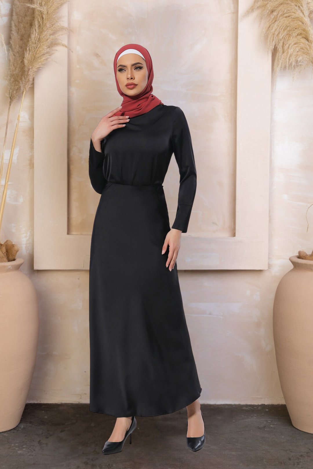 Woman in a long-sleeved black dress with red hijab showcasing a satin long sleeve skirt set