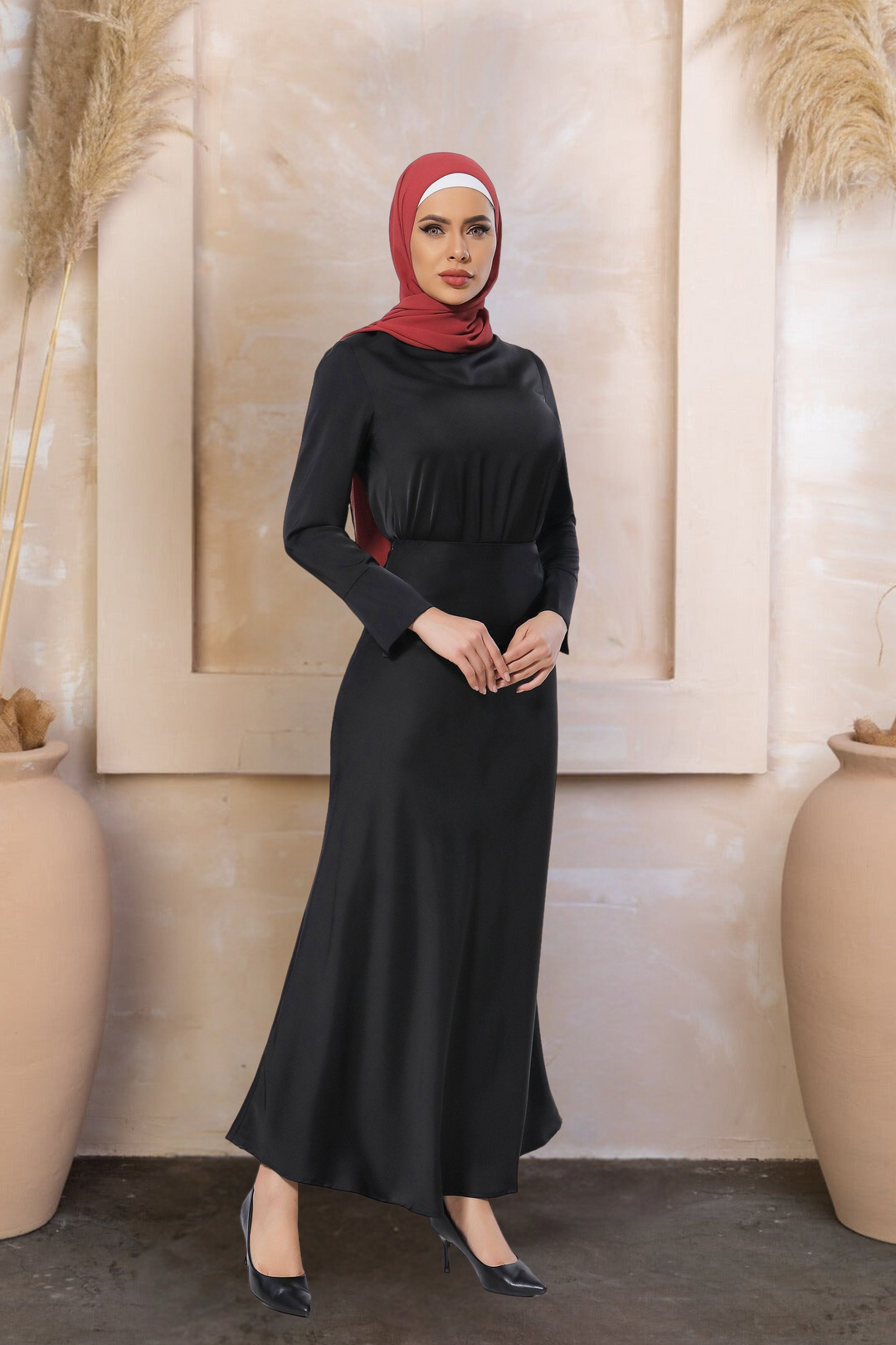 Woman in a long-sleeved black dress and red hijab wearing a satin long sleeve skirt set