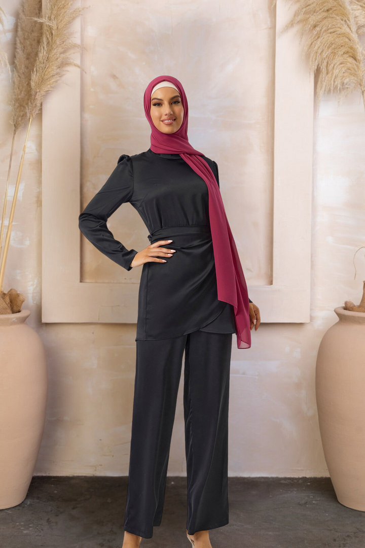 Woman in a modest black wrap tunic and pant set with maroon hijab