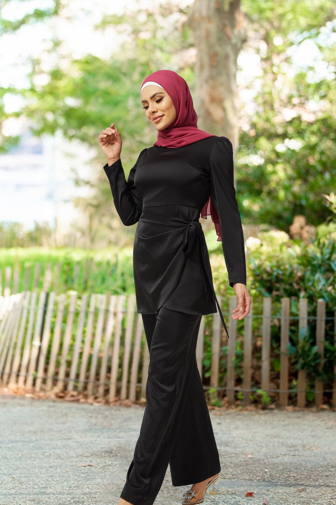 Woman in black satin pant set with maroon hijab, showcasing wrap tunic style