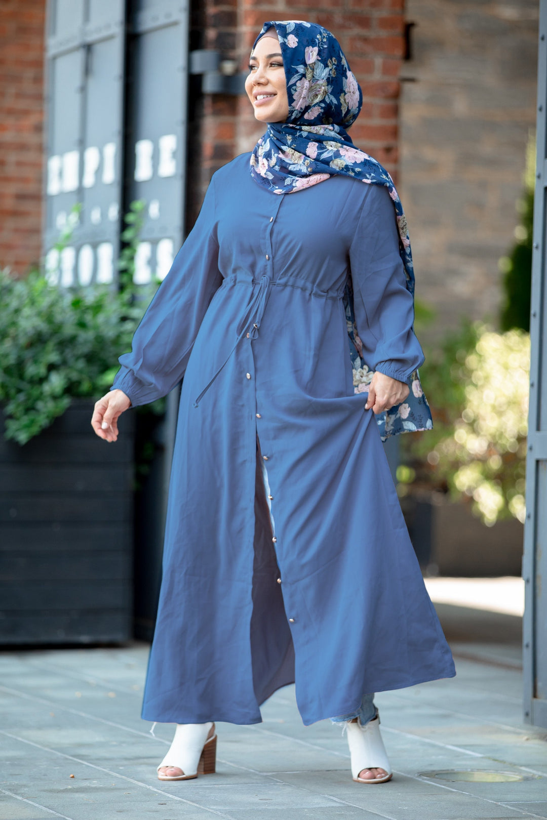 Woman in a blue dress and floral hijab wearing a blue button down maxi cardigan