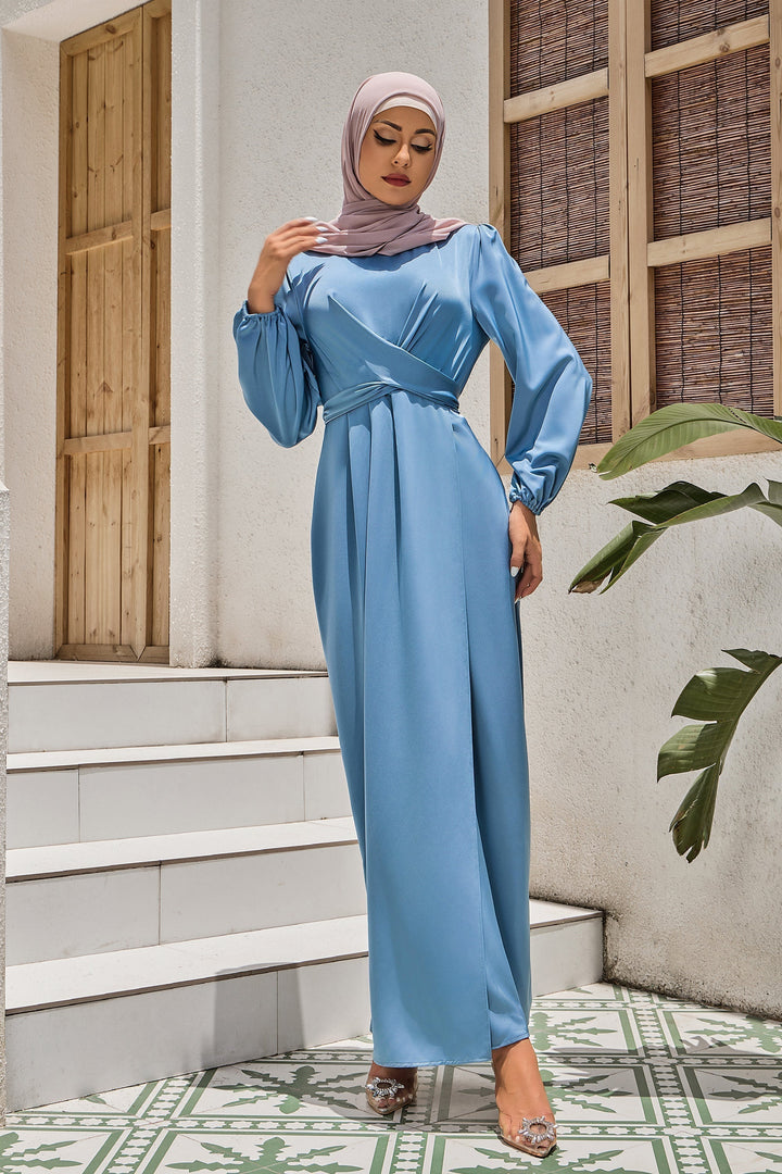 Woman in long-sleeved blue dress and hijab wearing a satin faux wrap maxi dress