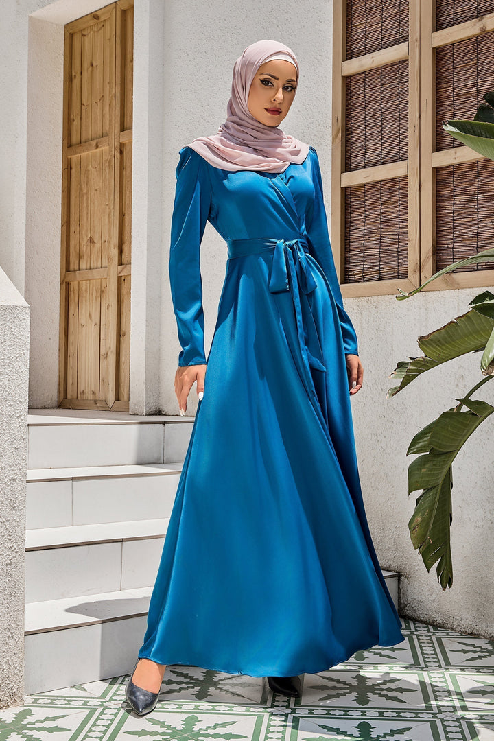 Woman in teal criss cross wrap dress with pink hijab, featured in Blue Criss Cross Side Tie Maxi Dress