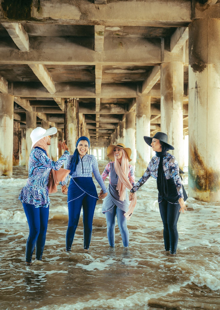 Four women in burkinis showcasing a Blue Houndstooth Print 3 Piece Modest Swimsuit