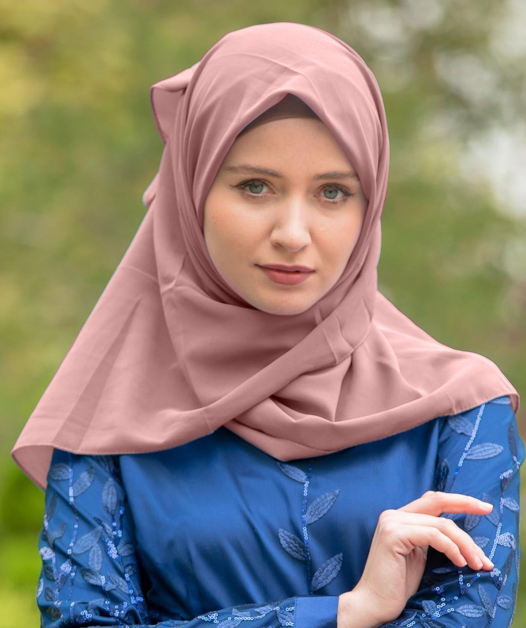 Woman in a pink chiffon hijab and blue dress showcasing the Blush Pink Chiffon Hijab