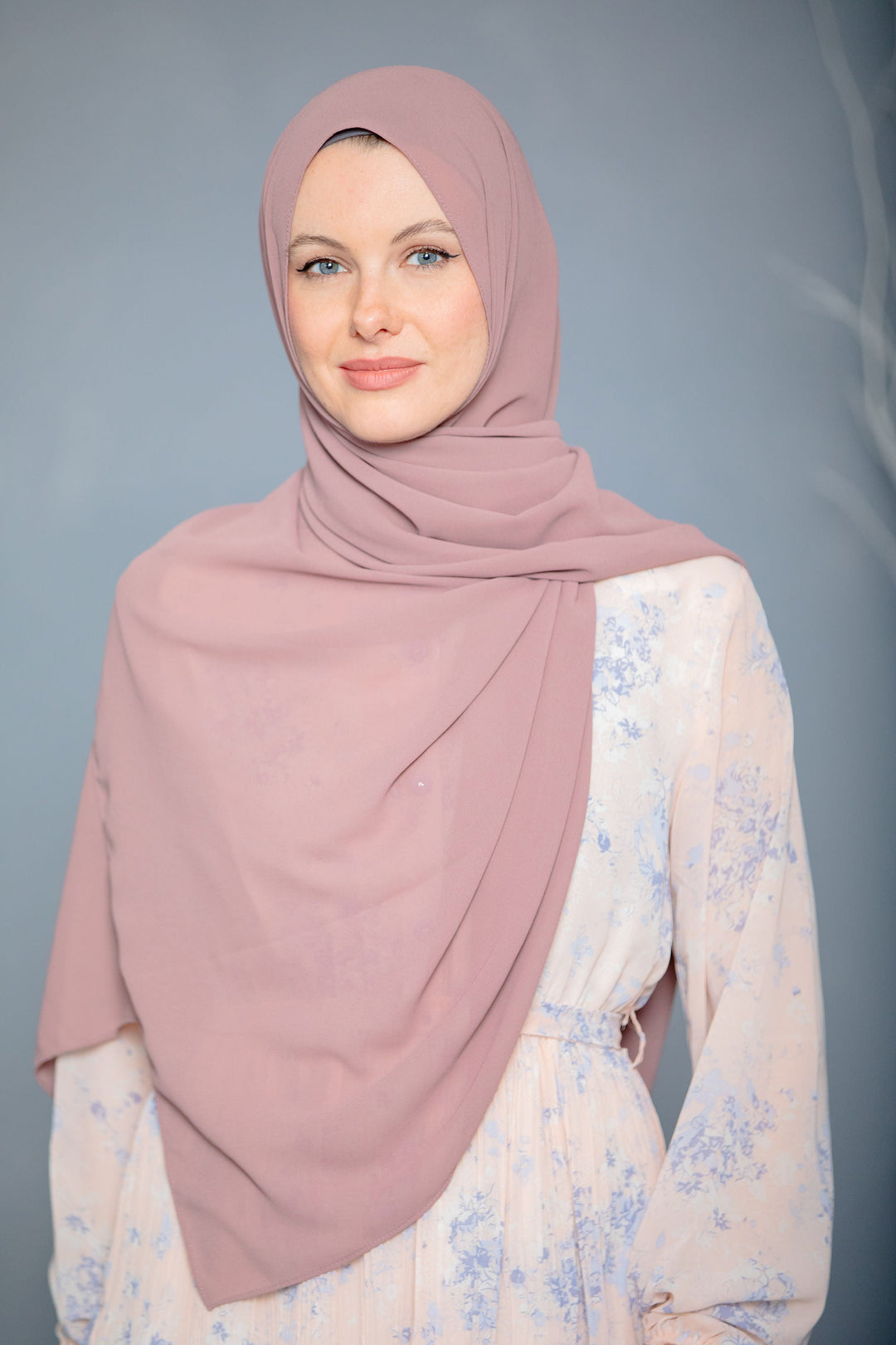 Woman in mauve hijab and floral dress showcasing Blush Pink Chiffon scarf