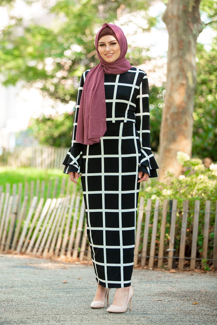 Woman in black and white checkered dress with maroon hijab and brown criss-cross underscarf