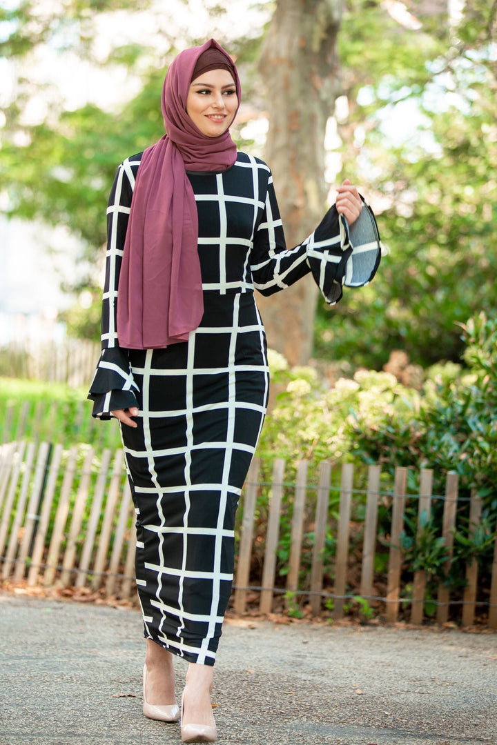 Woman in black and white grid dress featuring maroon hijab and brown criss-cross underscarf