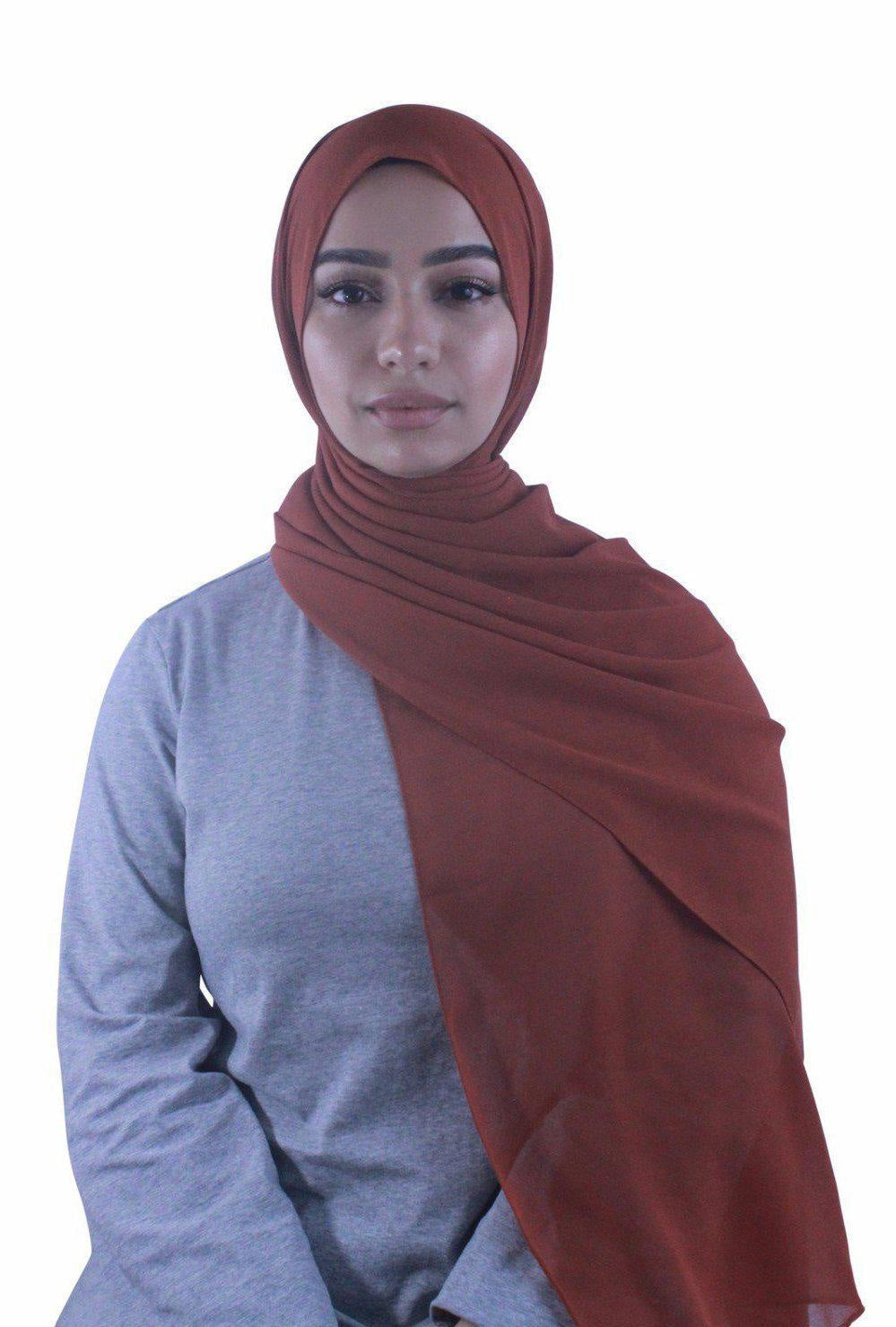 Woman wearing a reddish-brown chiffon hijab scarf, showcasing stylish headwear