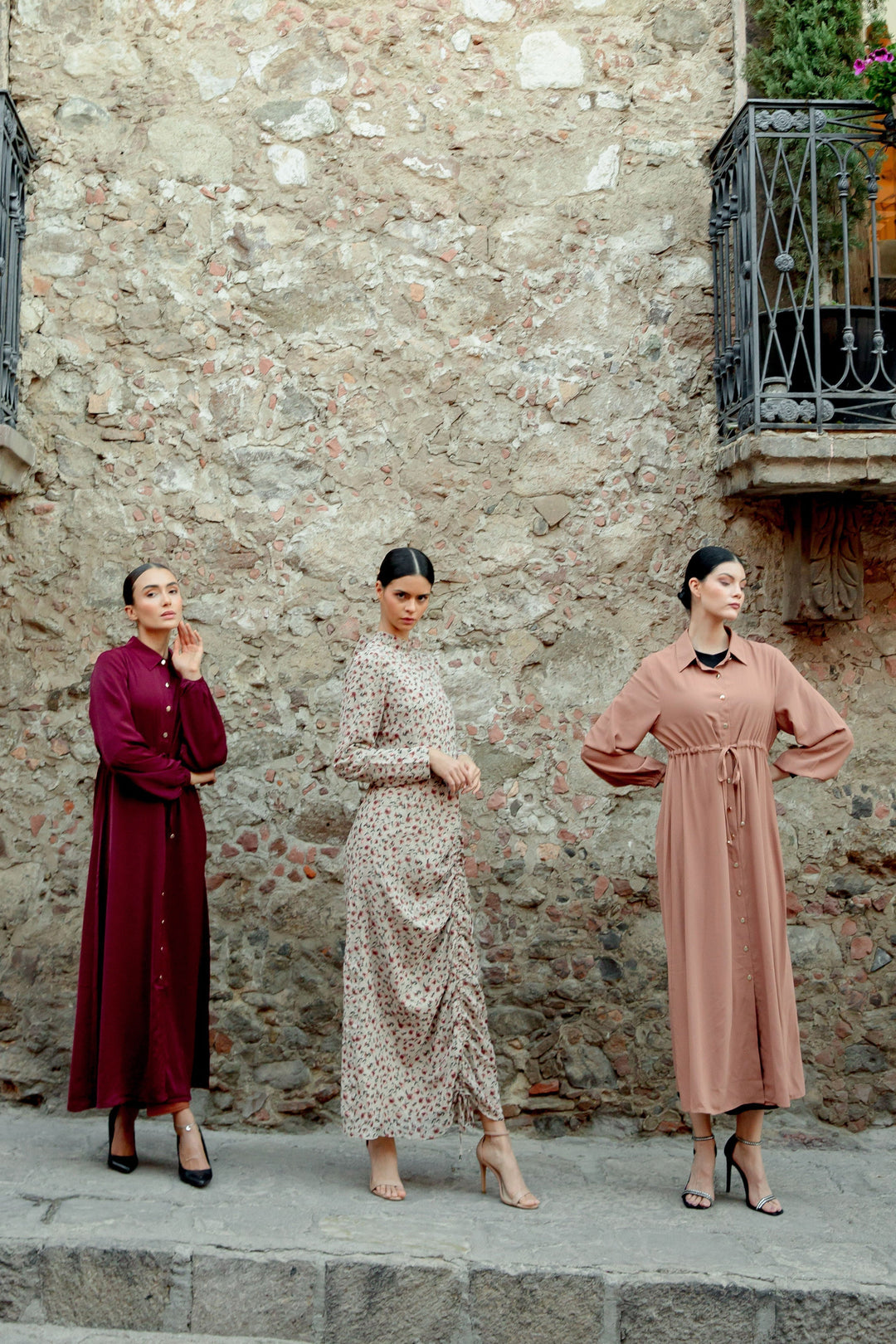 Three women modeling the Brown Button Down Drawstring Maxi Cardigan with stylish buttons