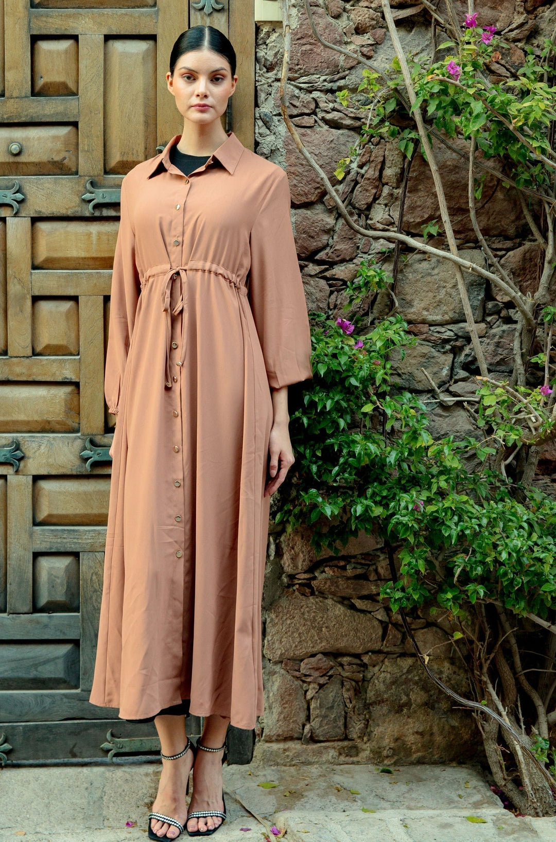 Woman wearing a Brown Button Down Drawstring Maxi Cardigan with buttons past the waist