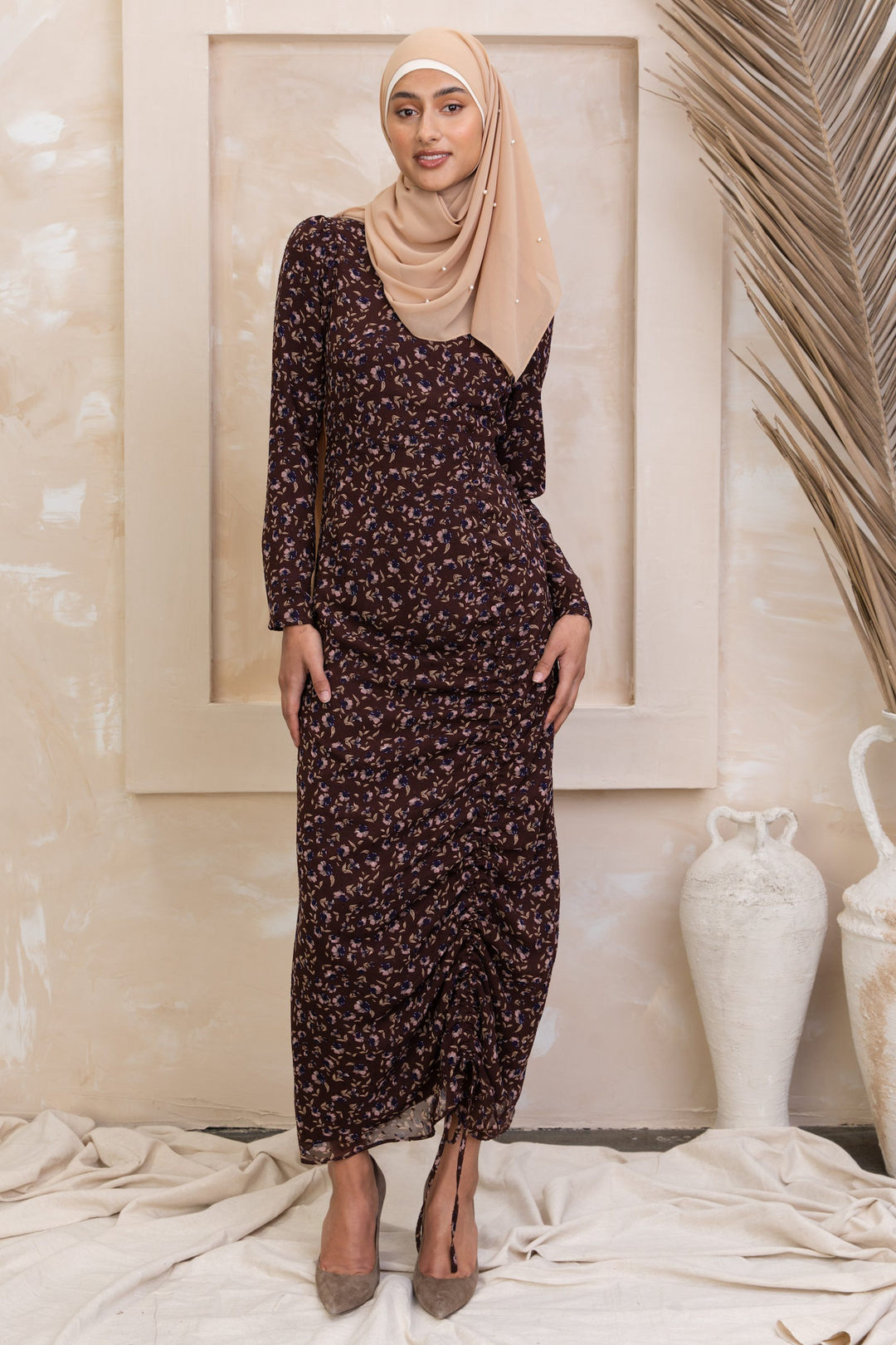 Woman wearing a brown floral ruched maxi dress with adjustable ruching, fully lined