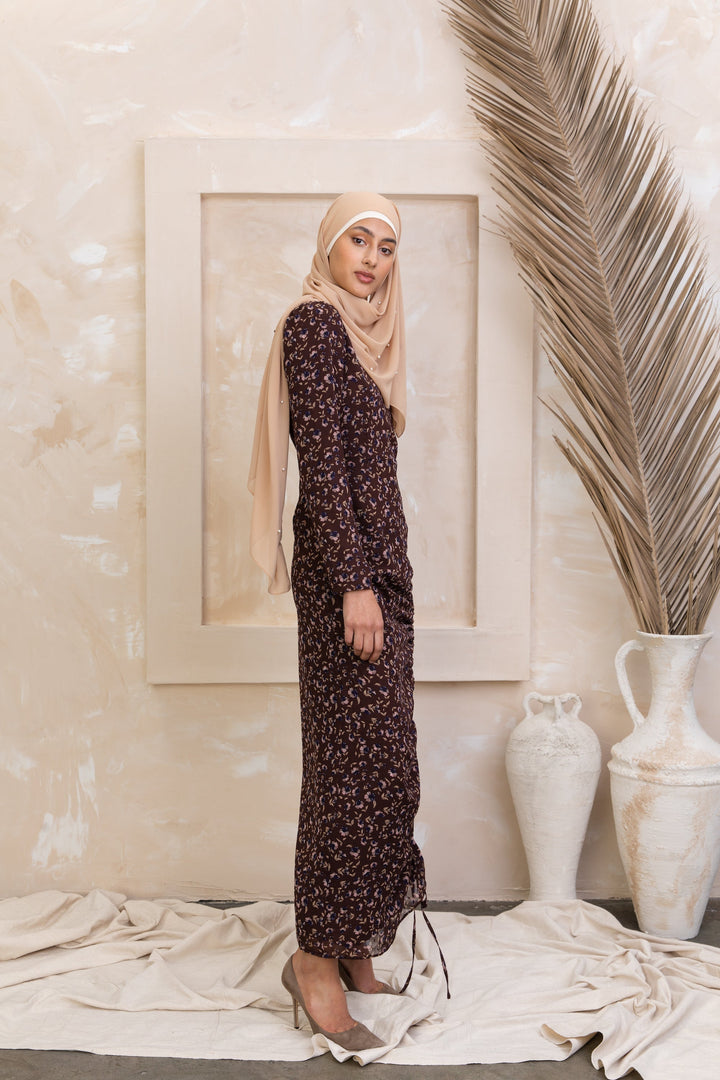 Woman wearing a brown floral ruched maxi dress with adjustable ruching and fully lined design