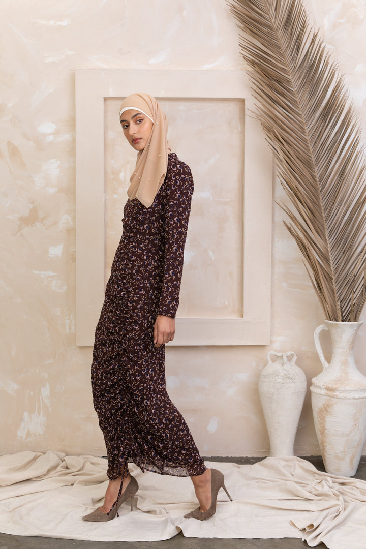 Woman in a floral dress and hijab showcasing the Brown Floral Ruched Maxi Dress