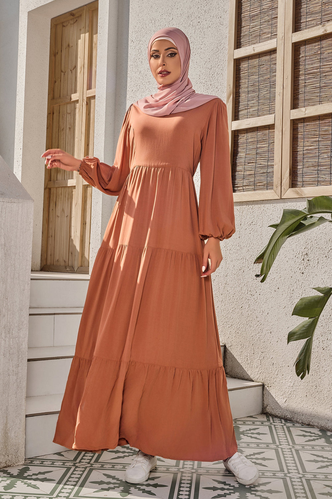 Woman in a brown tiered dress and pink hijab wearing a Burnt Orange Long Sleeve Maxi Dress