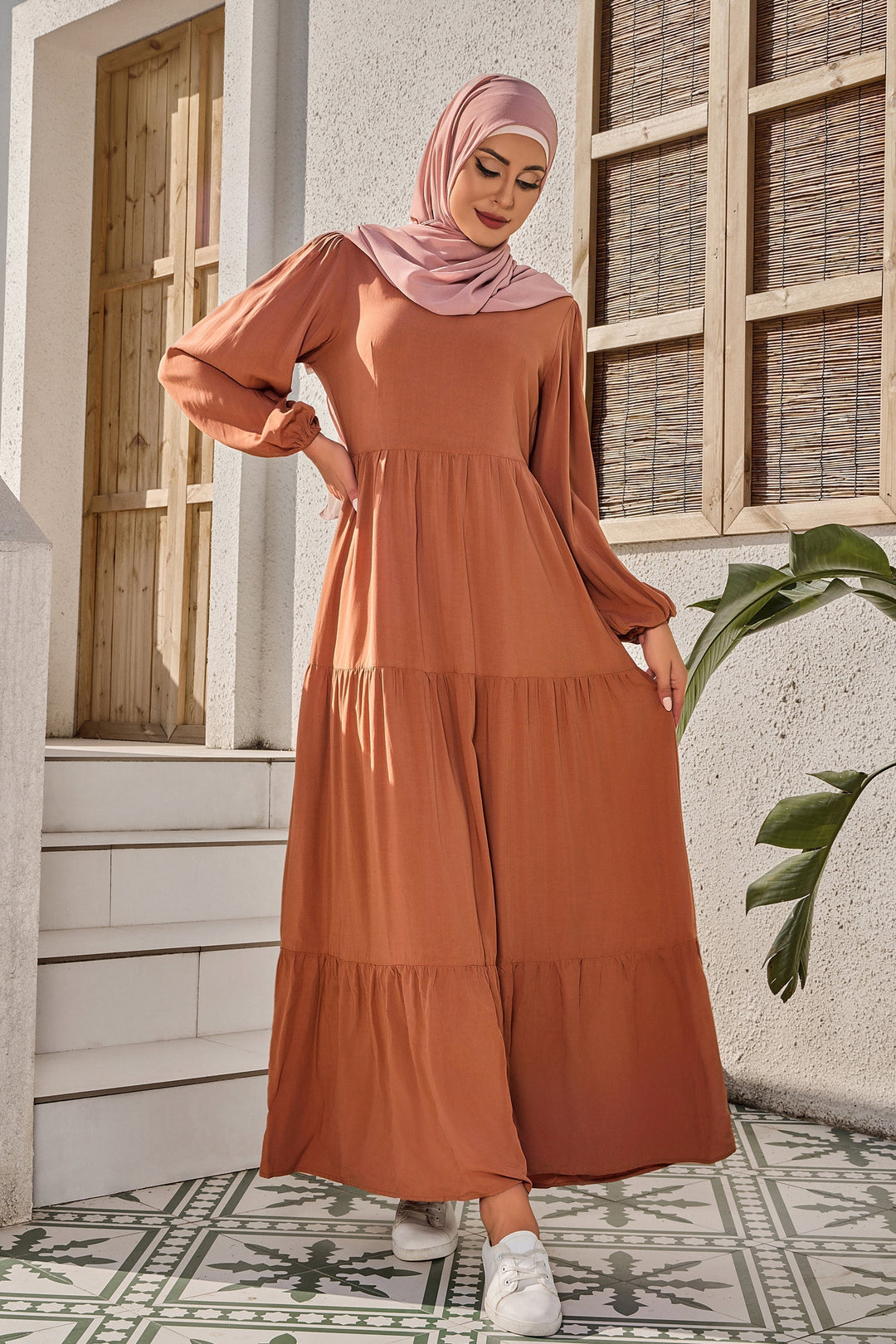 Burnt orange long sleeve maxi dress with tiered design and pink hijab styling