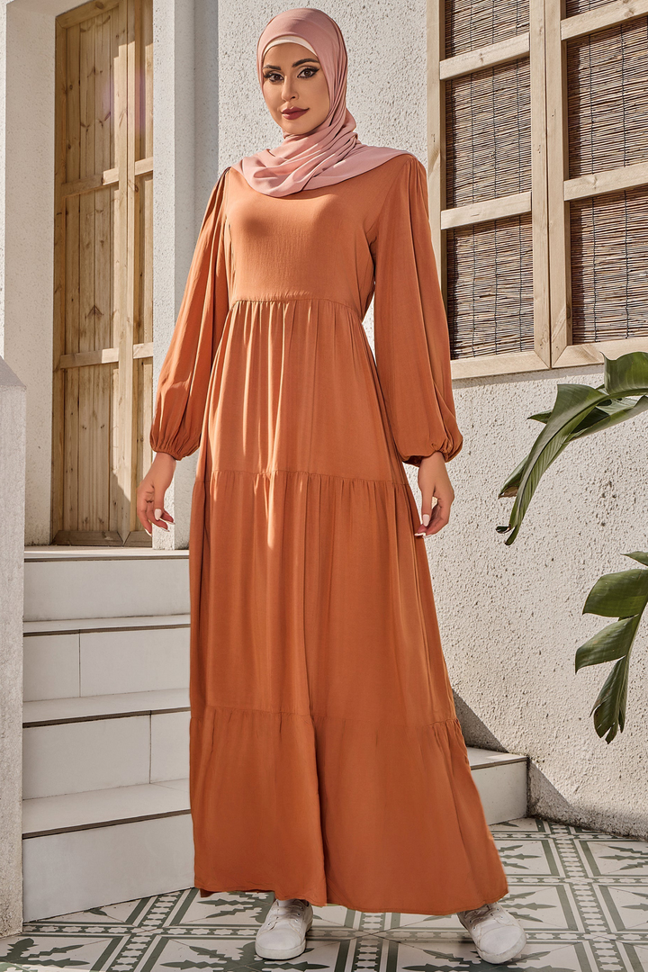 Long-sleeved burnt orange maxi dress with a tiered design and matching hijab