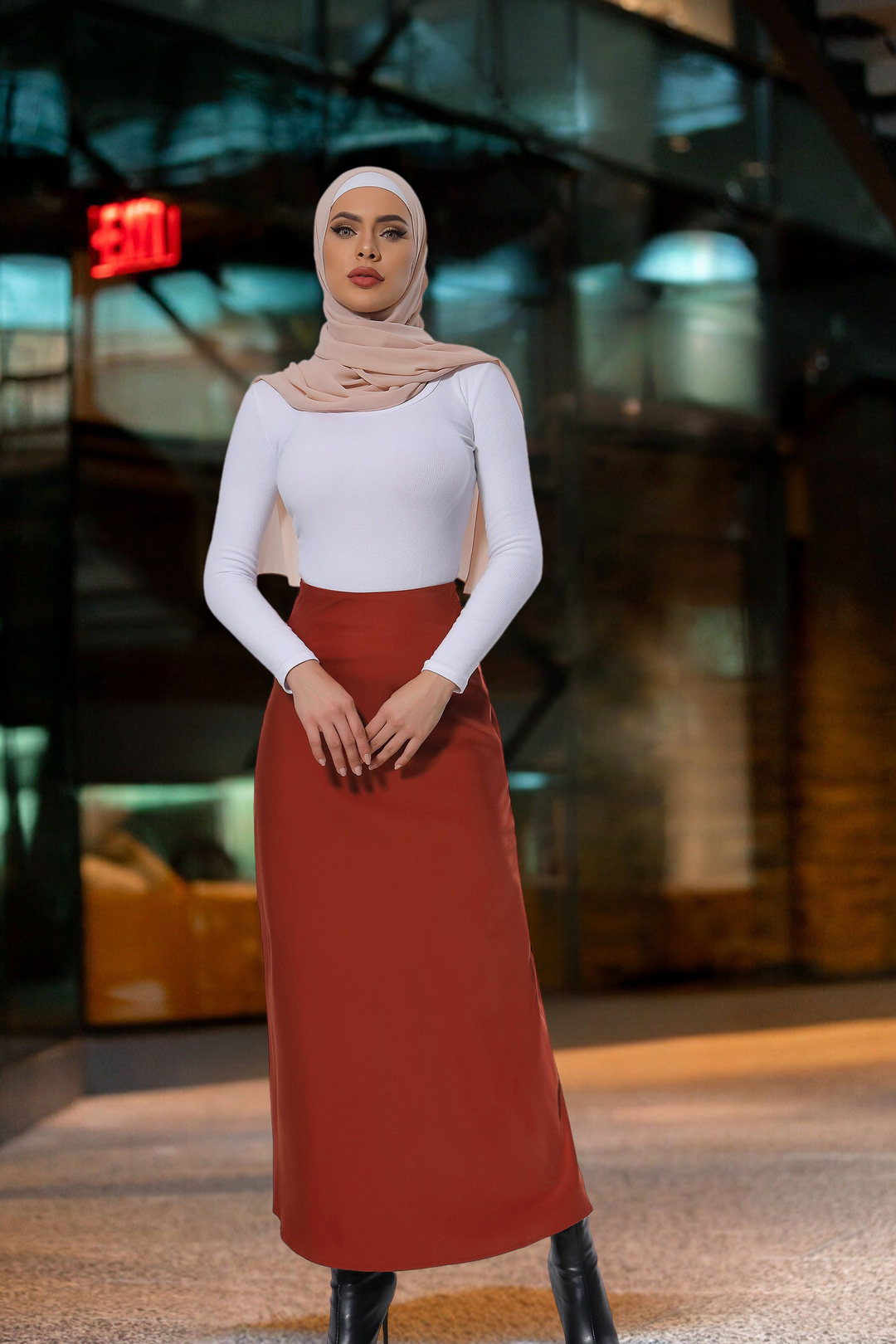 Woman in hijab wearing a white top with a Burnt Orange Satin Skirt, styled as a maxi skirt