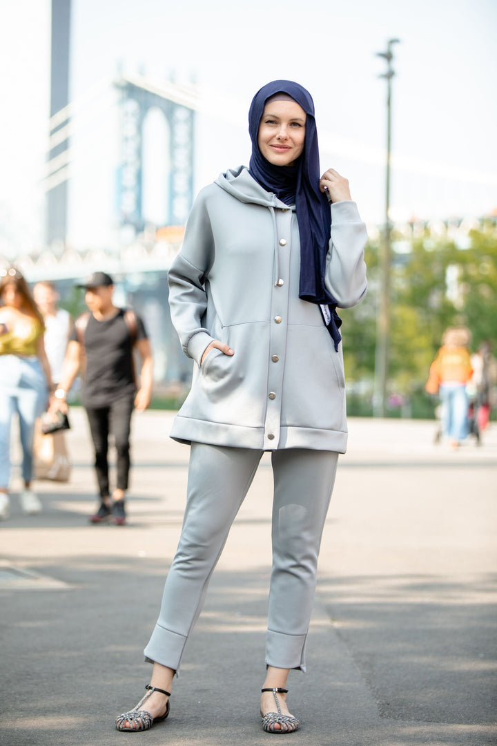 Woman in gray hoodie sweatshirt and navy hijab wearing a stylish pants set