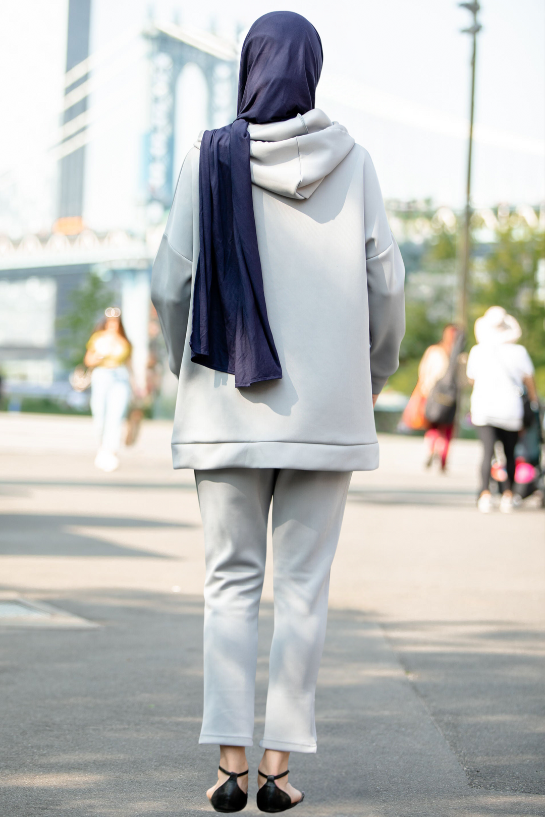 Woman wearing gray hoodie sweatshirt and pants set with dark blue hijab