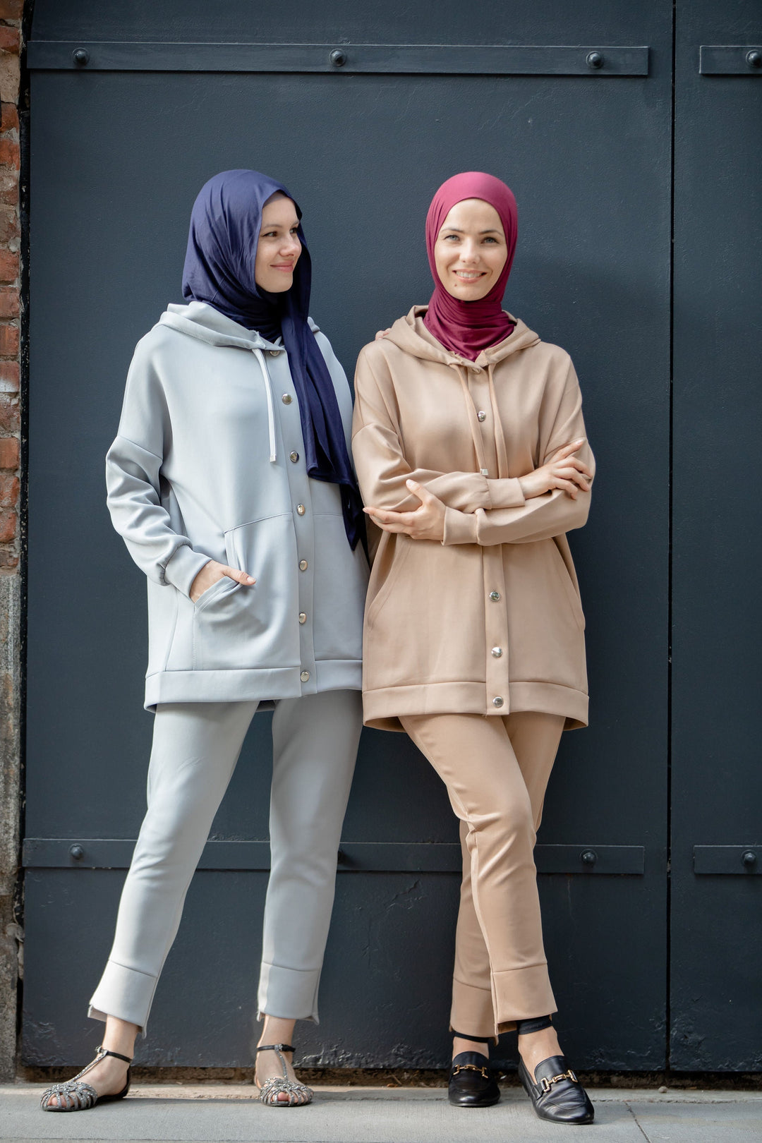 Two women in modest sportswear featuring a stylish hoodie sweatshirt and pants set