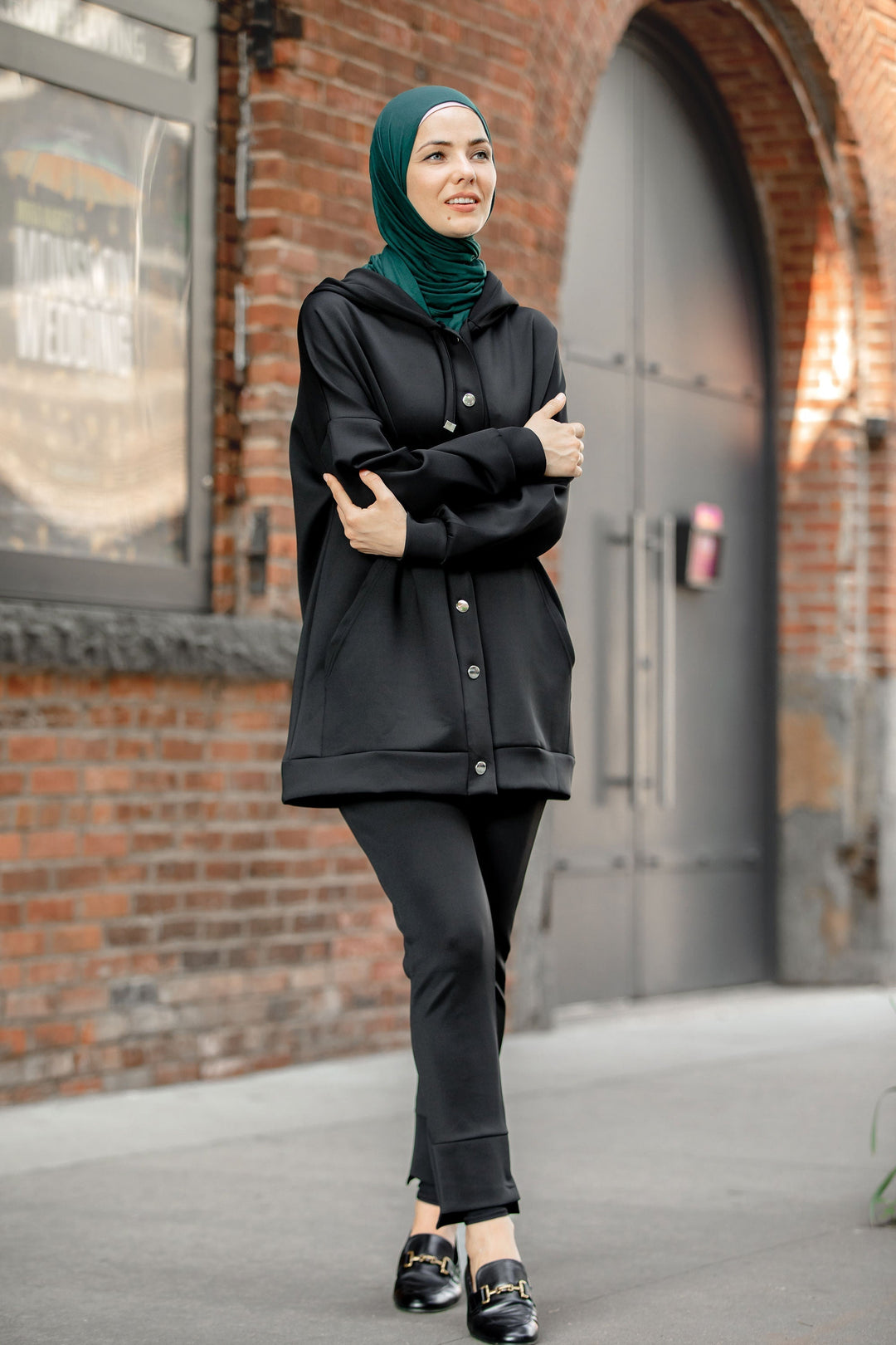 Woman in black hoodie sweatshirt and pants set with green hijab for a stylish look