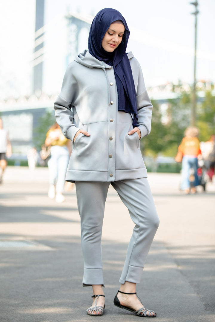 Woman in gray hoodie sweatshirt and navy hijab wearing a stylish pants set