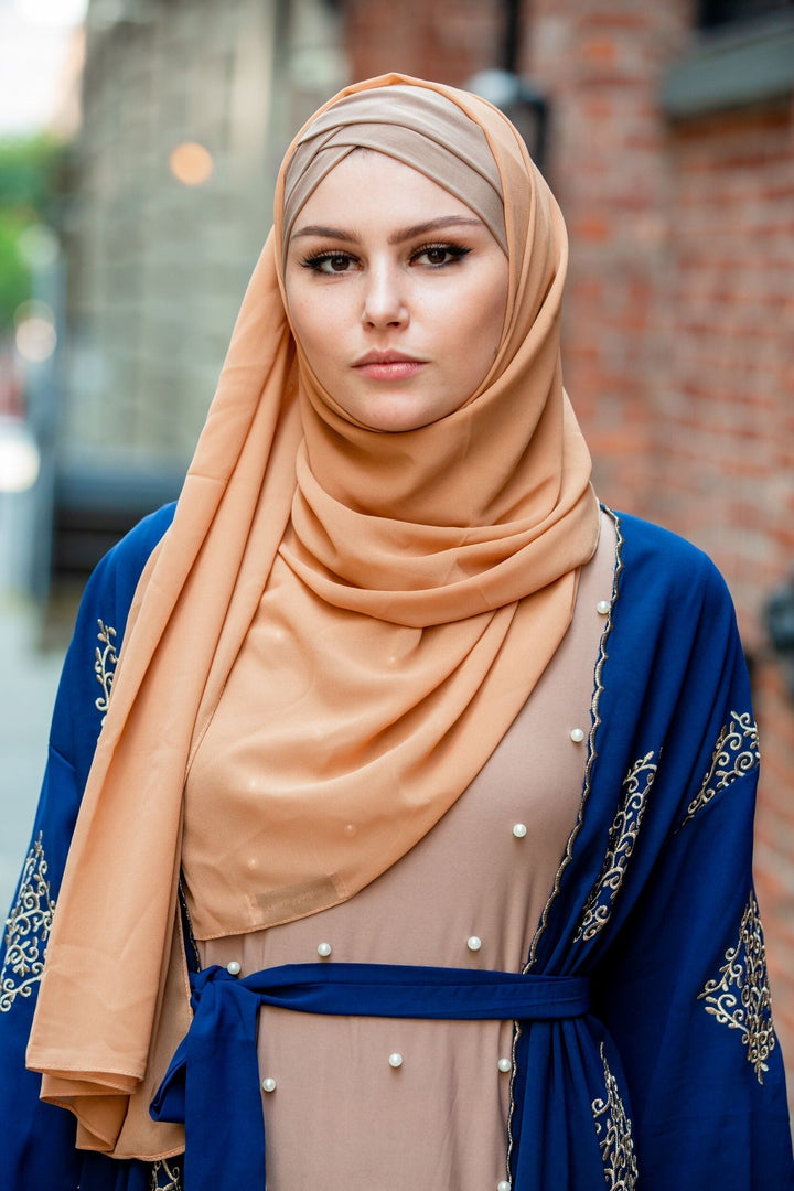 Woman wearing a hijab and robe with a Camel Chiffon Scarf for stylish modesty