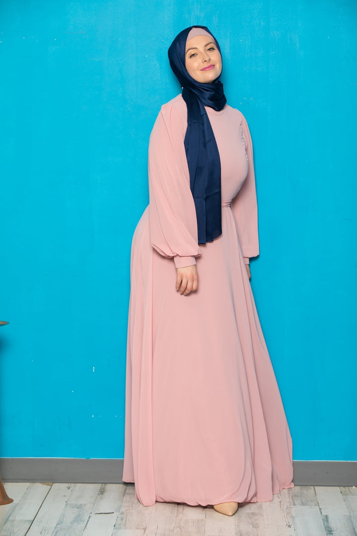 Woman in pink dress and navy hijab wearing a Chiffon Long Sleeve Gown with belt included