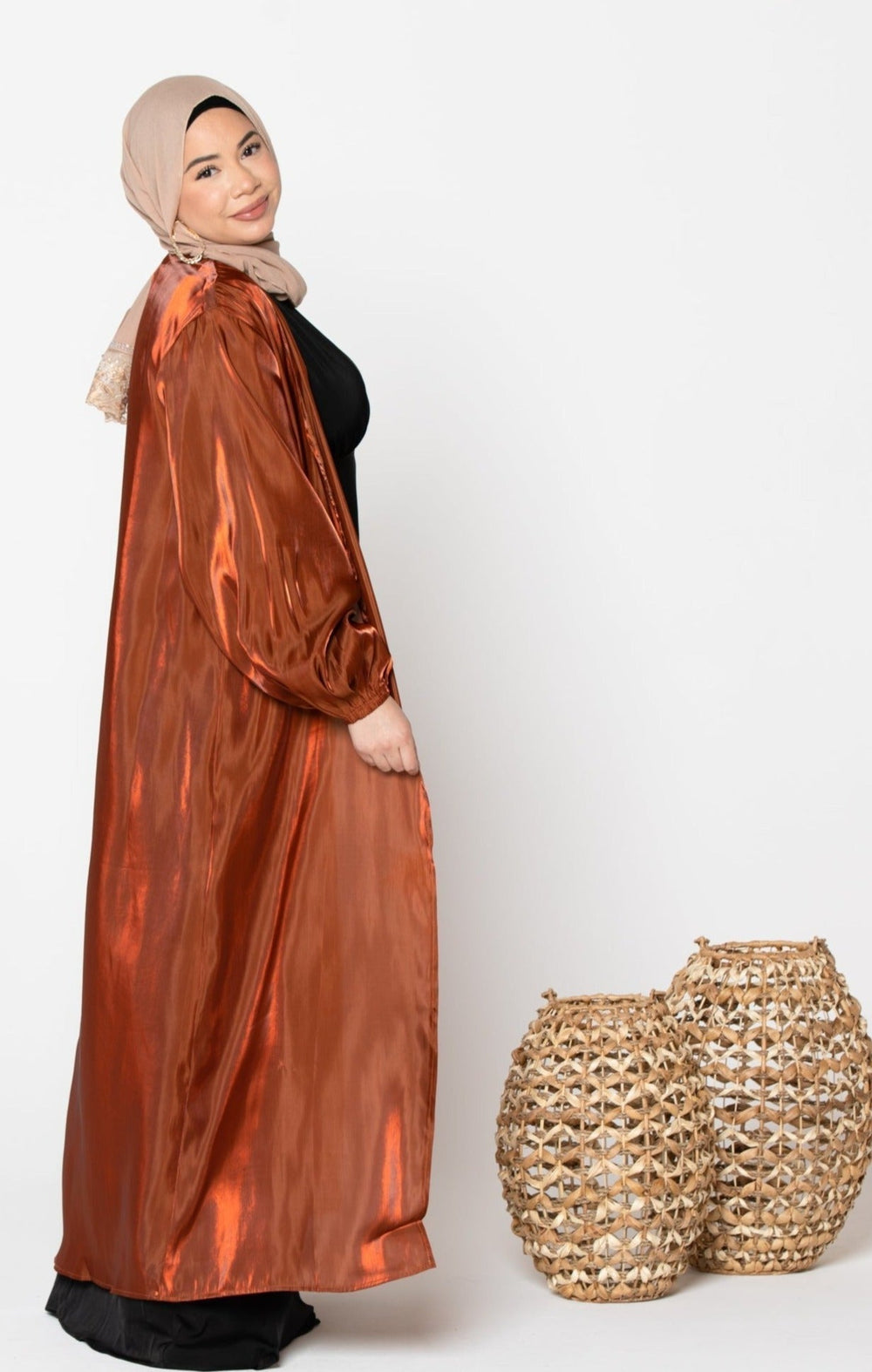 Woman in a shiny copper-colored robe and hijab wearing a Copper Organza Open Abaya