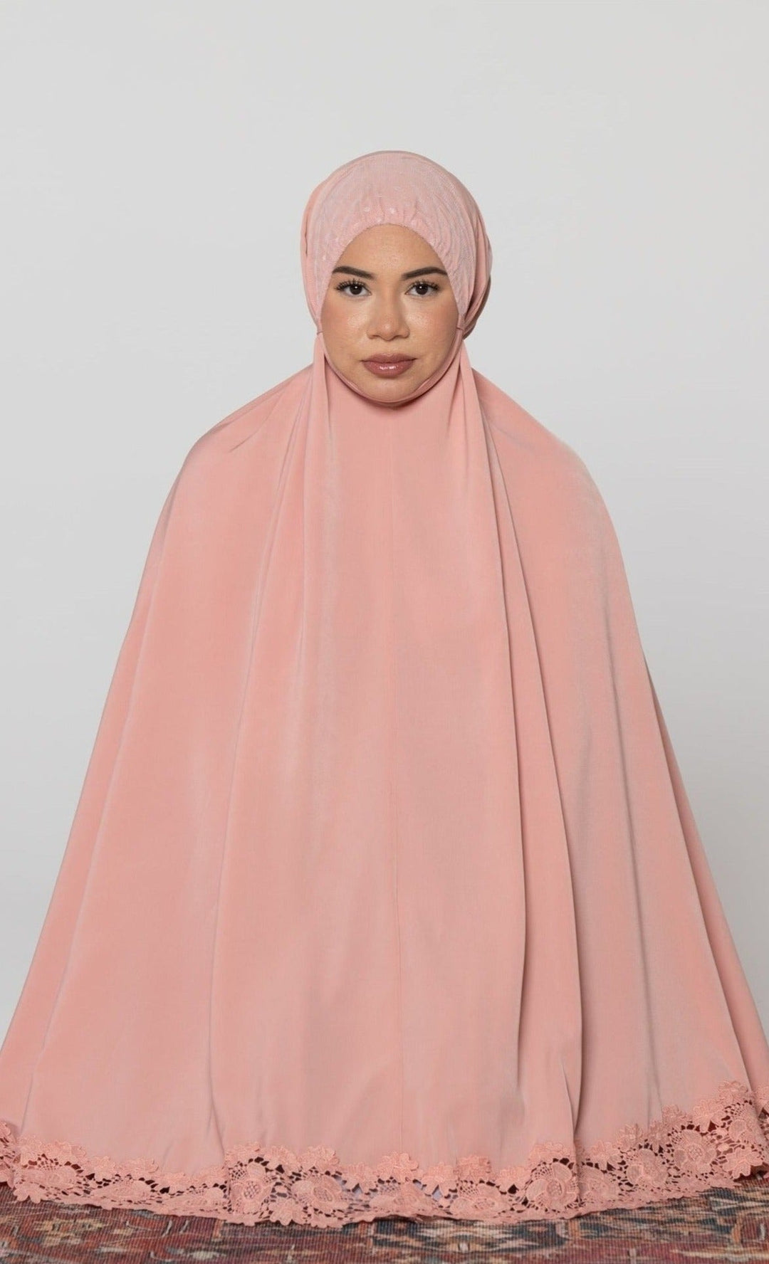 Woman in a pink prayer garment wearing a Coral Two Piece Lace Salah Prayer Outfit