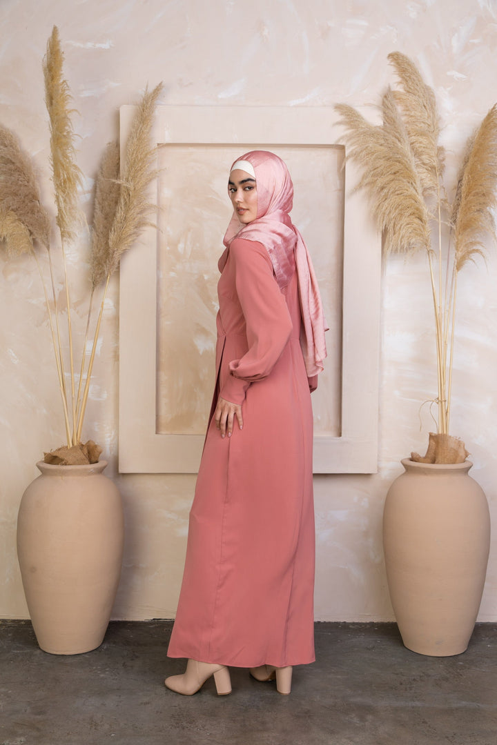 Woman in a long pink dress and hijab wearing a Coral Wrap Maxi Dress