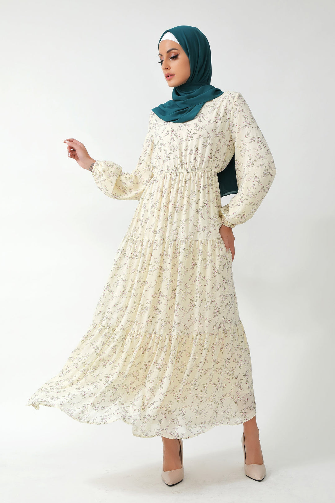 Woman in a long-sleeved floral tiered maxi dress featuring a cream floral design