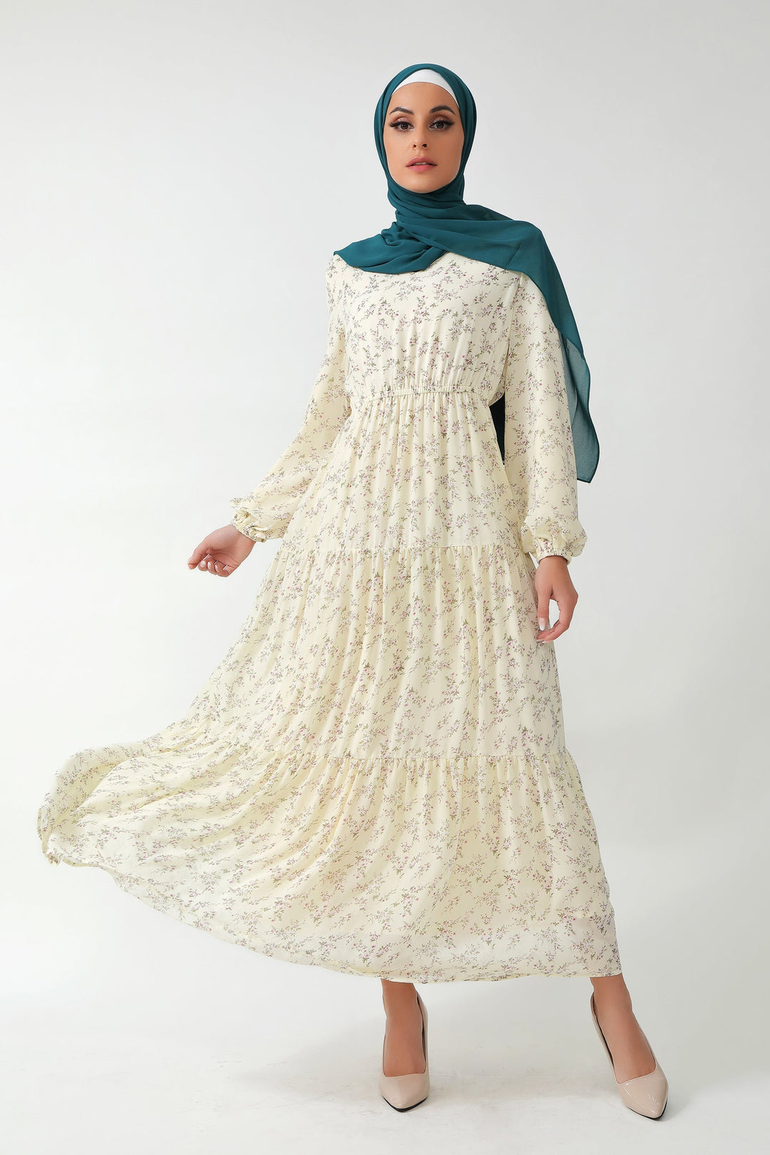 Woman in a cream floral tiered maxi dress with teal hijab for stylish summer looks