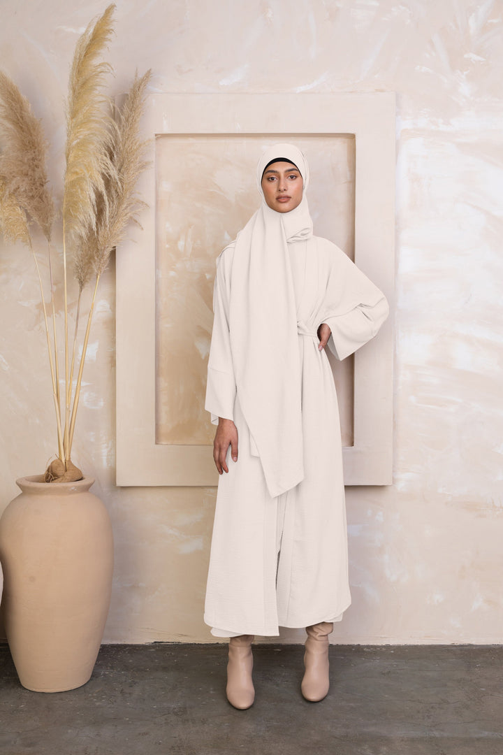 Woman wearing a cream four piece open abaya set, showcasing modest fashion style