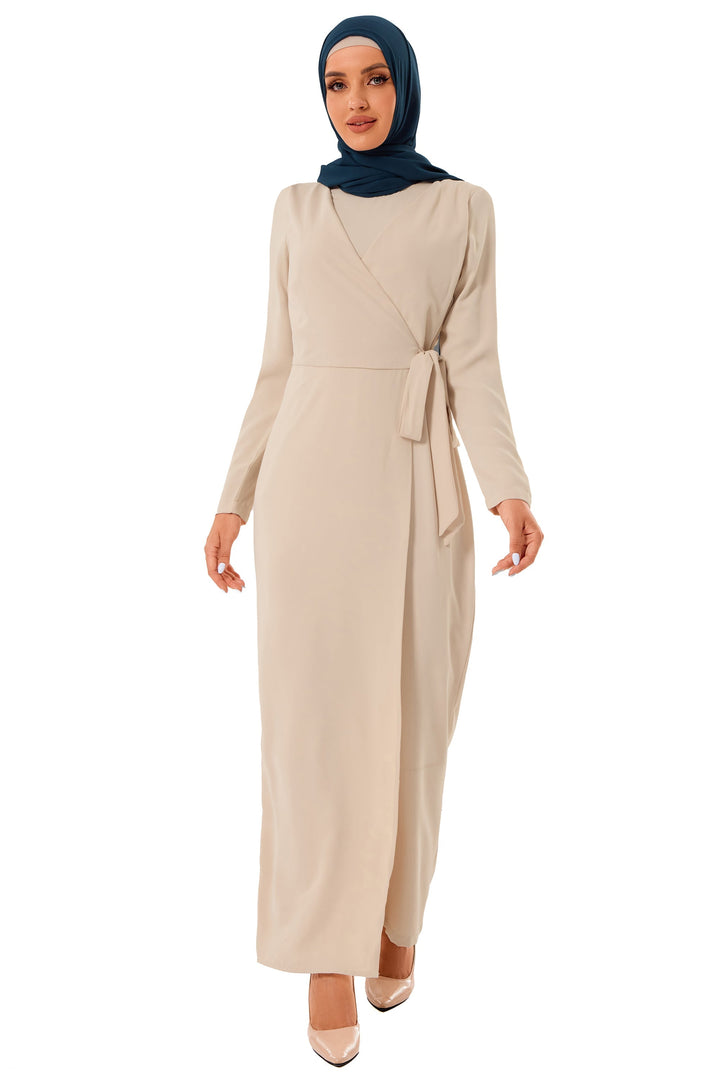 Woman in a beige wrap dress style knot jumpsuit with dark blue hijab