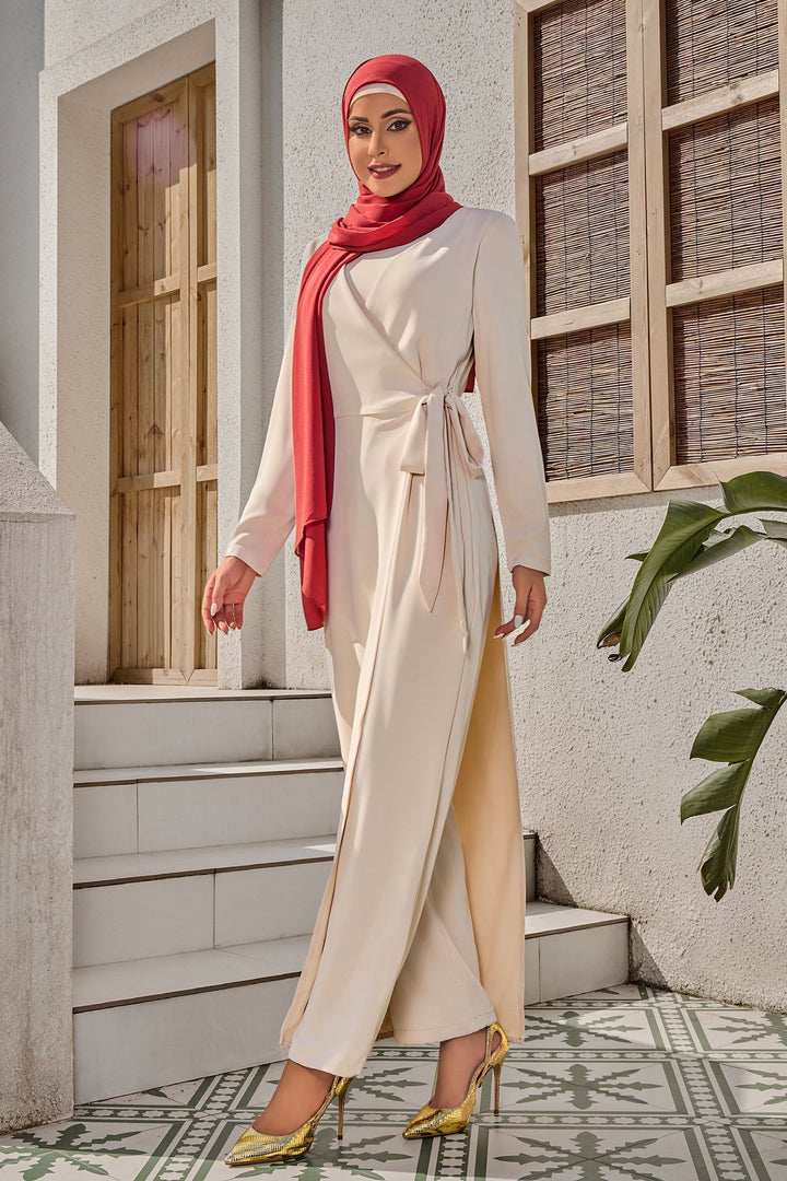 Woman in a modest red hijab wearing a Cream Side Knot Jumpsuit styled as a maxi dress