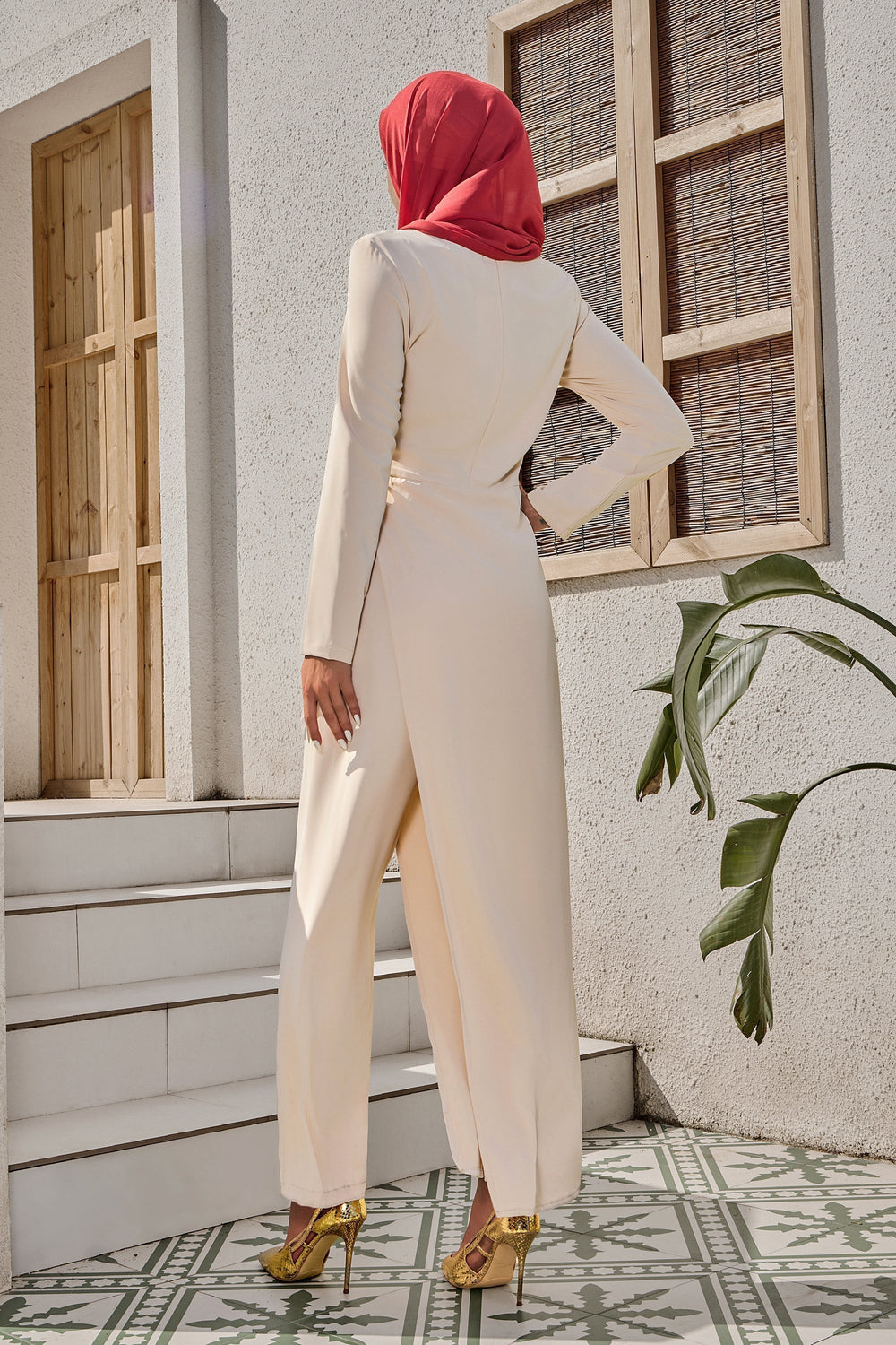 Woman in cream Side Knot Jumpsuit with red hijab styled like a maxi dress