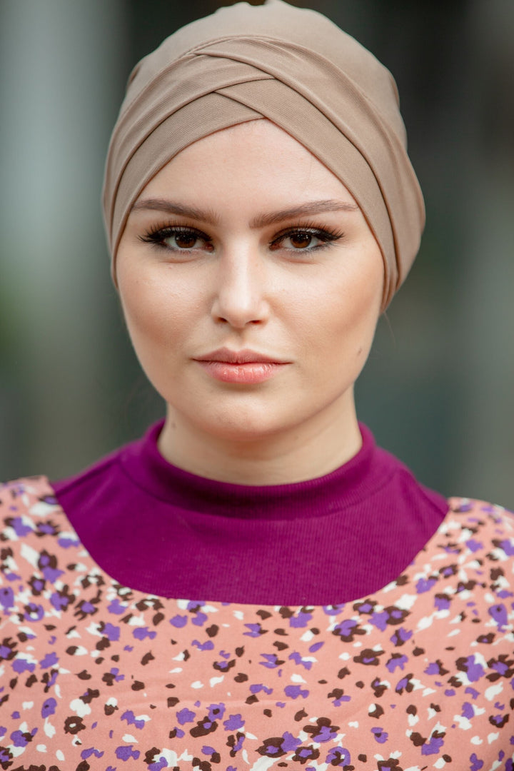 Woman in floral dress wearing tan Tube Hijab Underscarf for stylish head covering