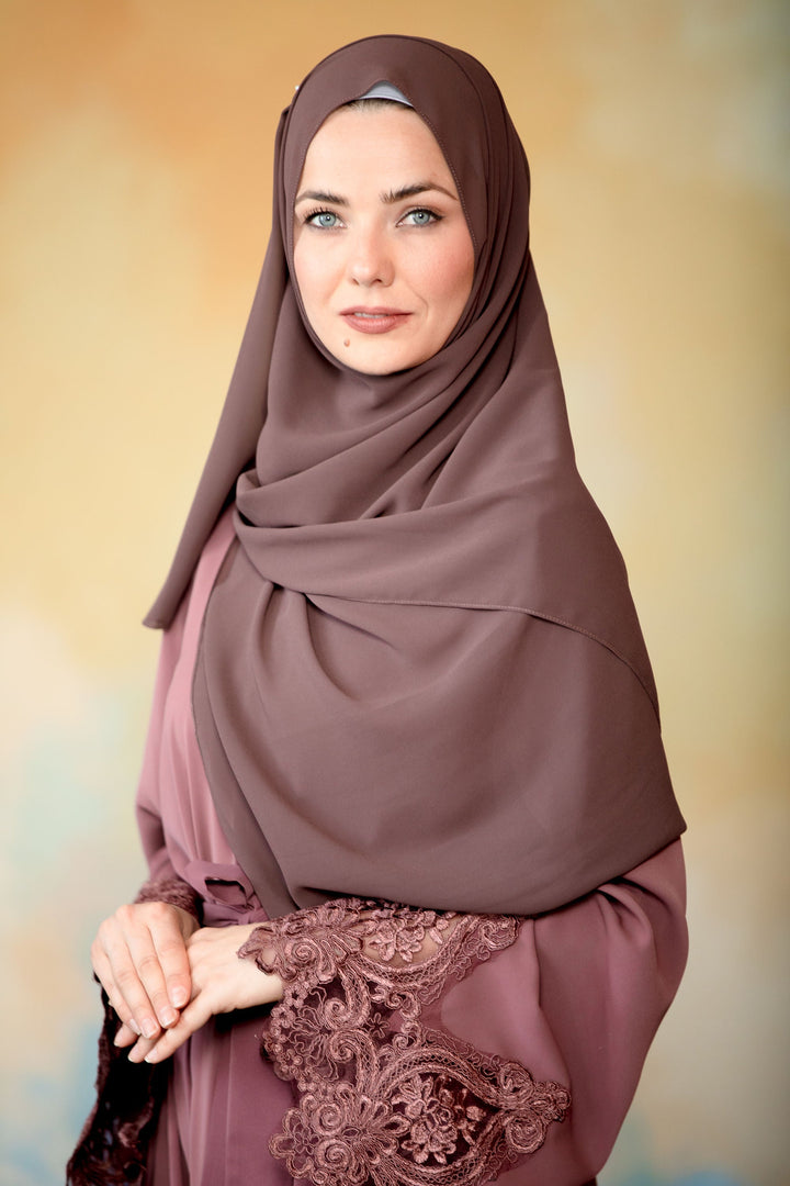 Woman in a mauve chiffon scarf and maxi dress with lace cuffs