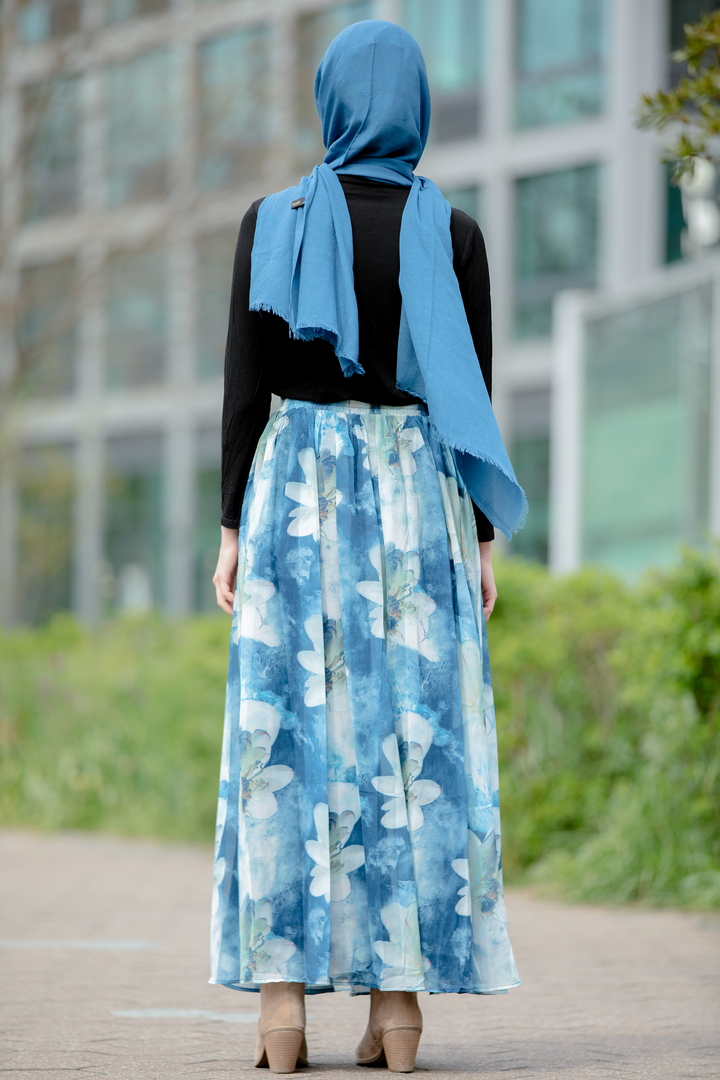 Woman in blue floral skirt and hijab wearing Day Dreams Floral Maxi Skirt on clearance