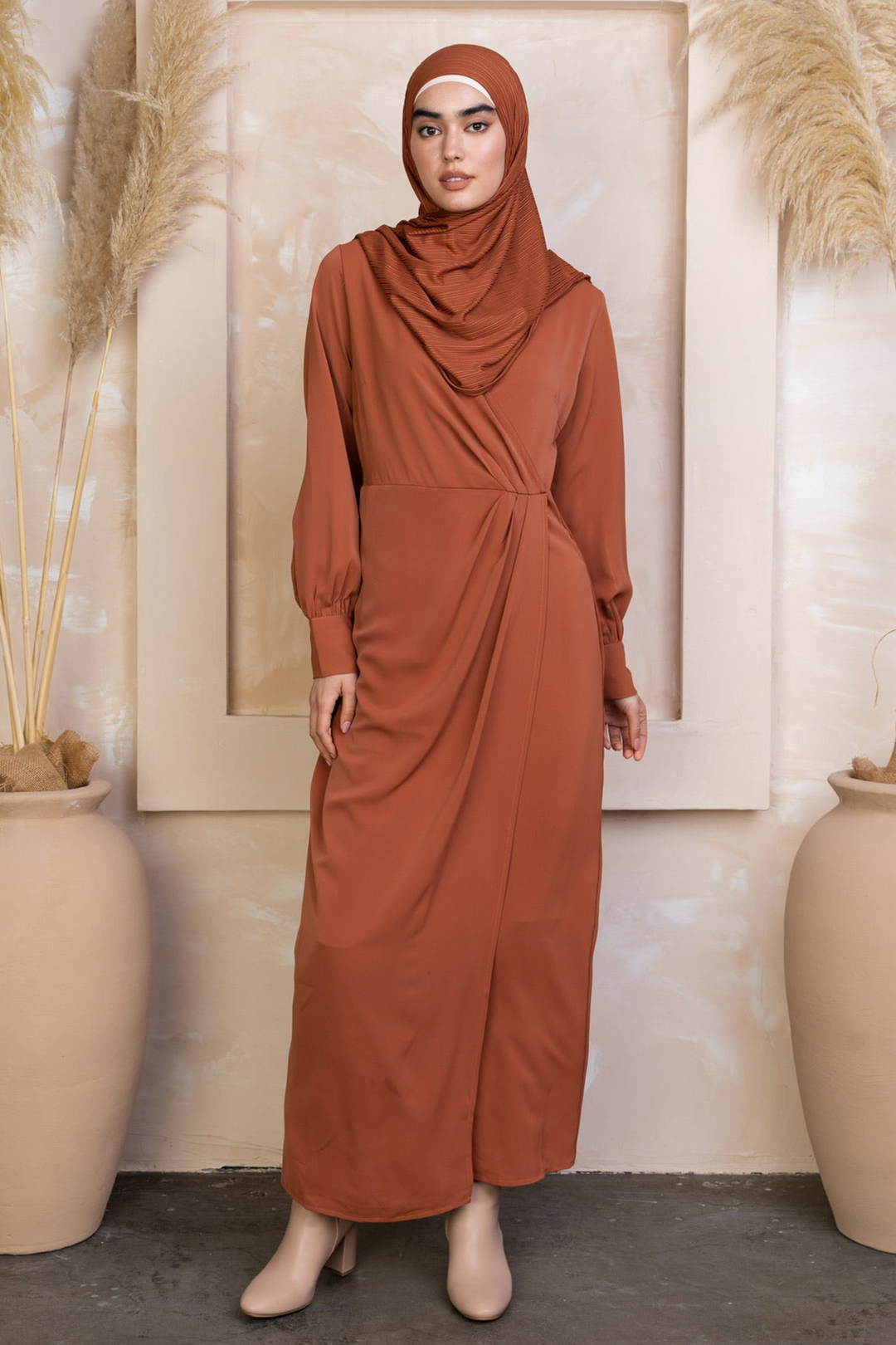 Woman in rust-colored Deep Cider Wrap Maxi Dress with long sleeves and hijab