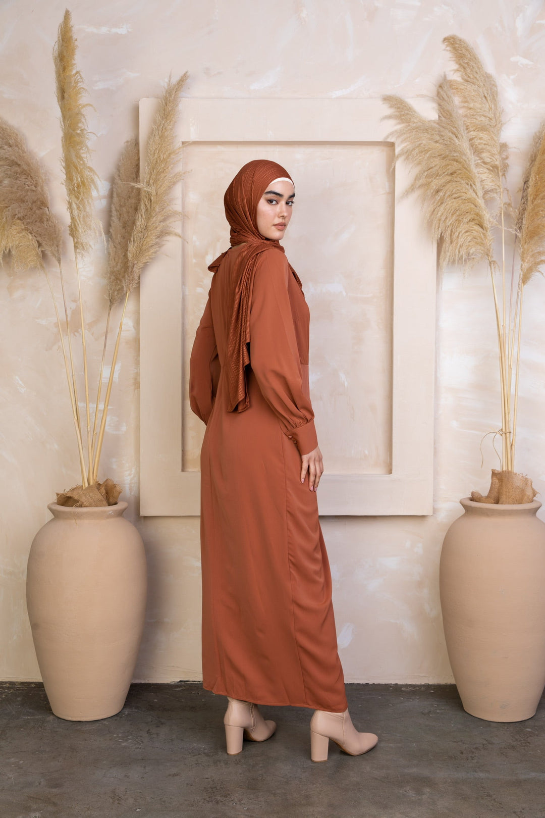 Woman in a long-sleeved Deep Cider Wrap Maxi Dress with criss cross neckline