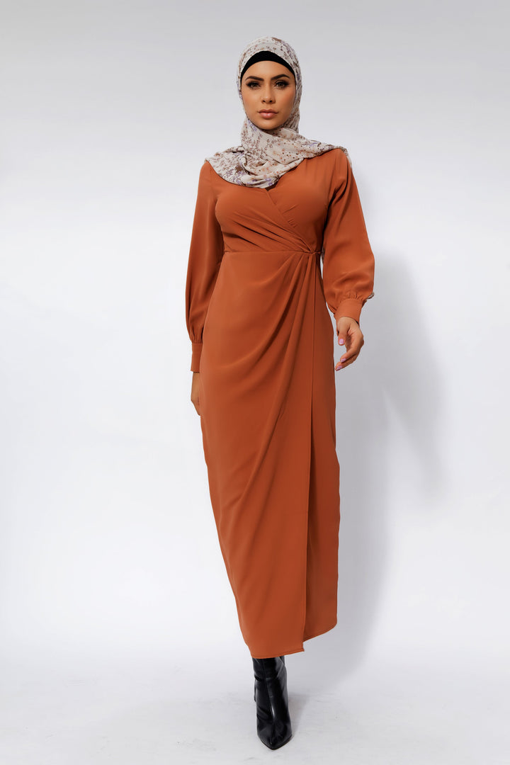 Woman in a rust-colored dress with criss cross neckline and patterned hijab, showcasing Deep Cider Wrap Maxi Dress