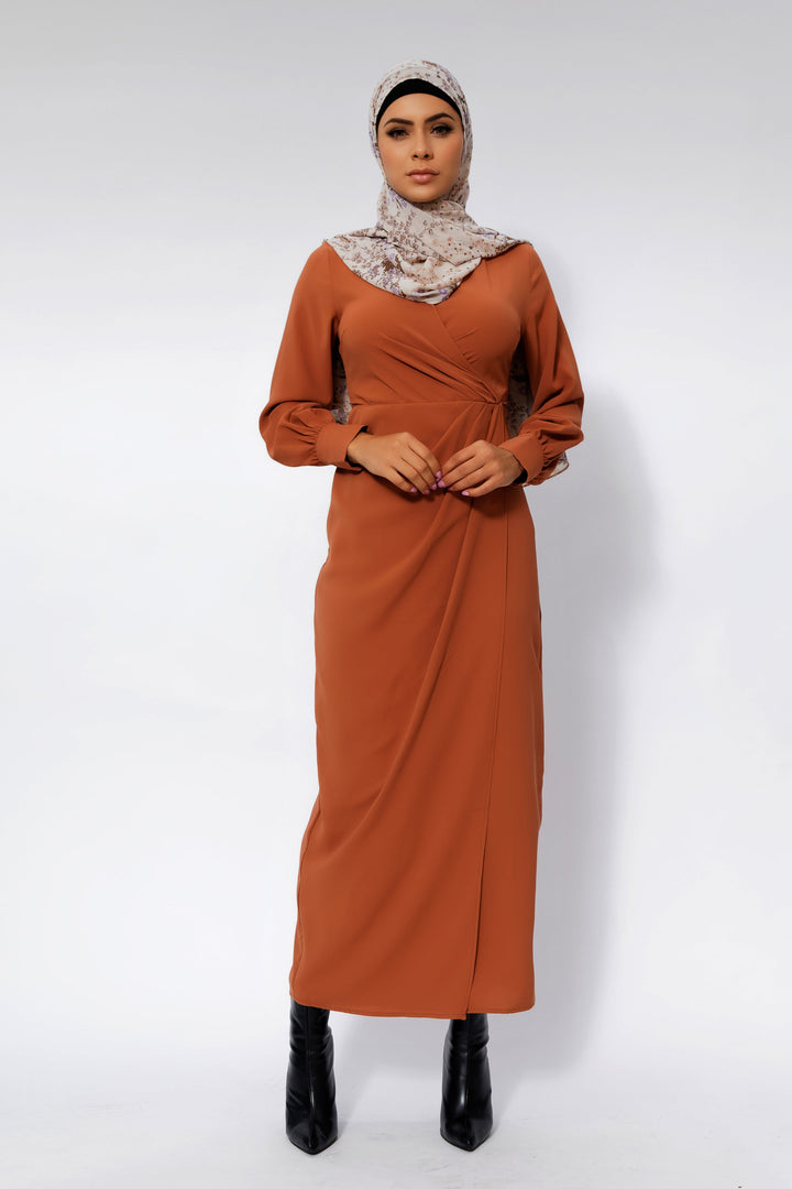 Woman in a long-sleeved Deep Cider Wrap Maxi Dress with criss cross neckline