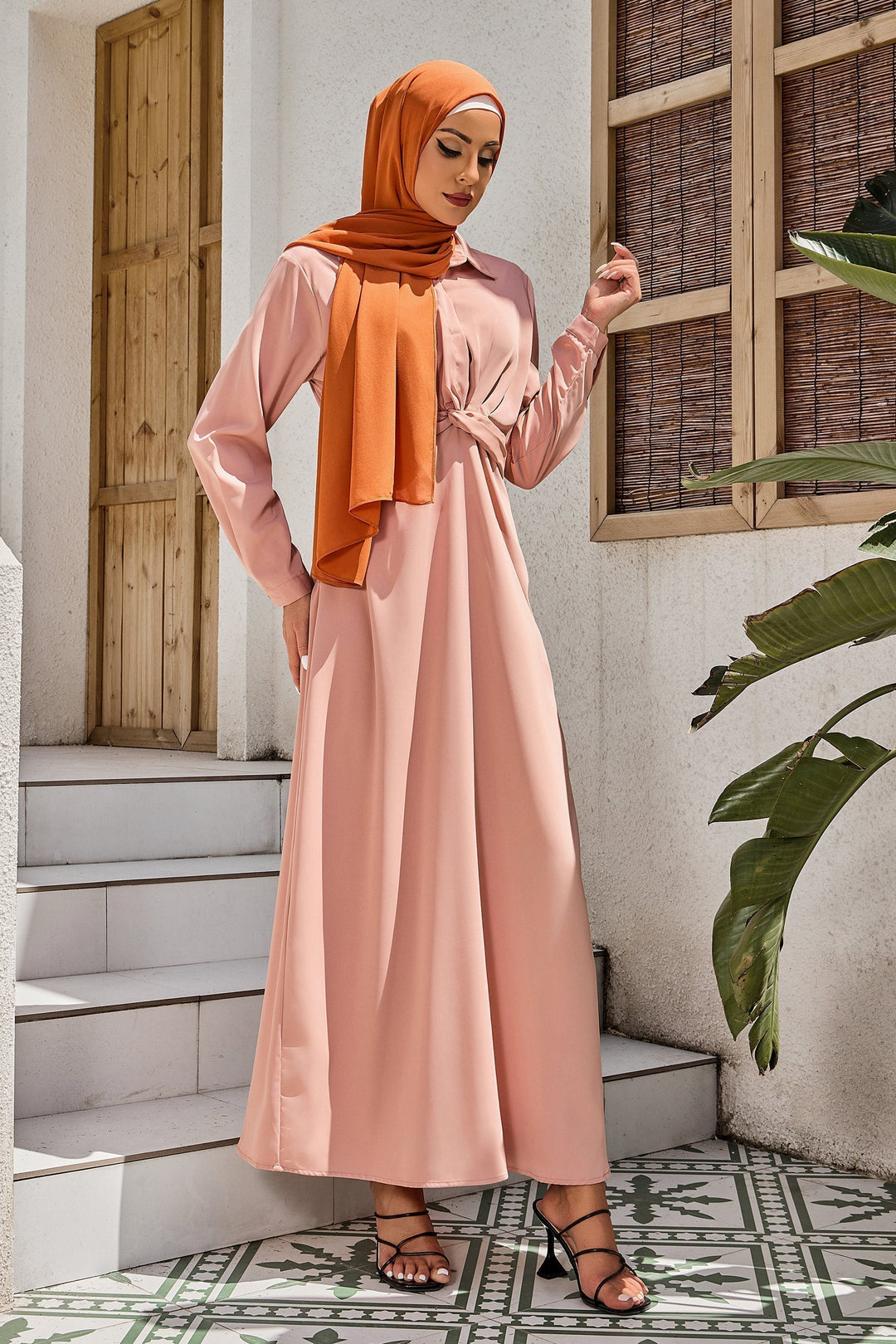 Woman in a dusty pink criss cross button down maxi dress with hijab