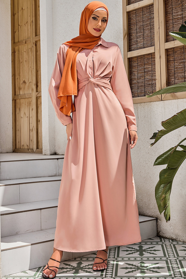 Woman in a dusty pink criss cross button down maxi dress with a hijab