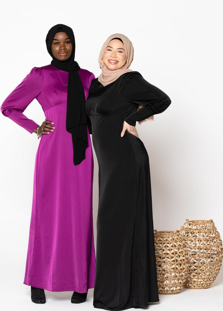 Two women in fuschia satin long sleeve maxi dresses with hijabs