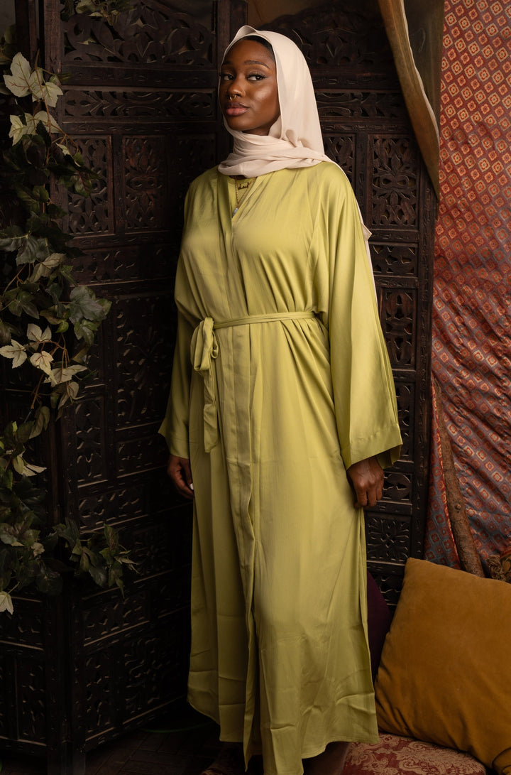 Woman in a green robe and hijab showcasing a Grass Green Sleeveless Dress and Open Abaya Set